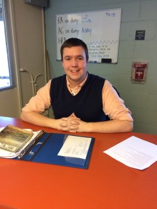 This is a picture of President Little sitting at his desk, working as the acting building floor RA. He is smiling and has his hands folded.